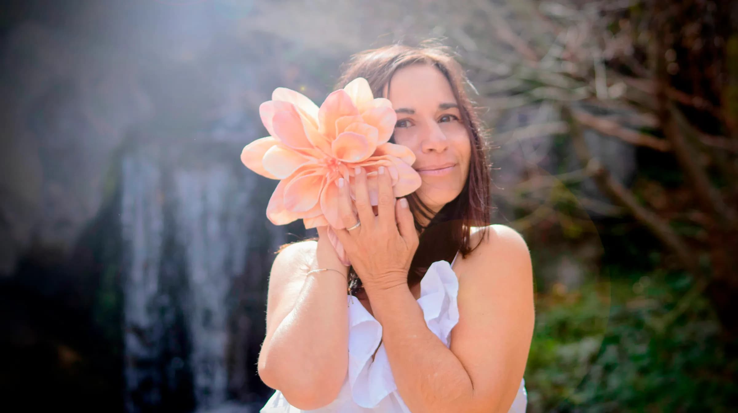 Valérie Duvernet tenant une grande fleur rose devant son visage